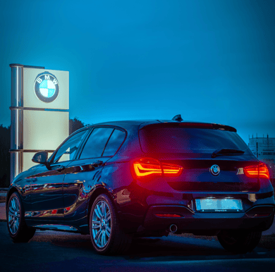 BMW 1 series at dusk with tail lights on