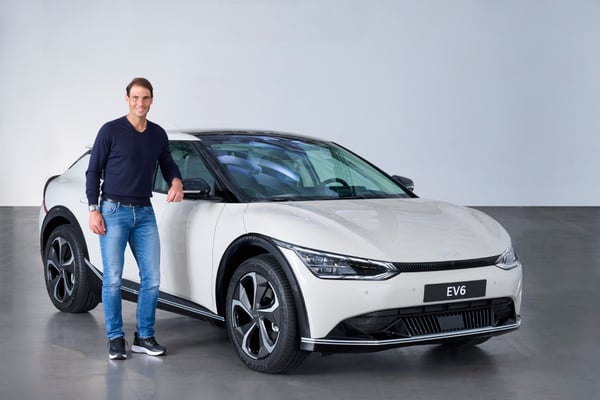 Rafael Nadal stood outside a white Kia EV6 GT