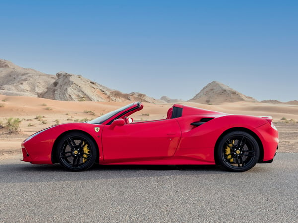 Red Ferrari 488 Spider parked in a desert