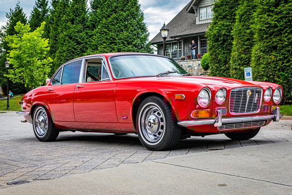 Jaguar XJ6 in red outside a house