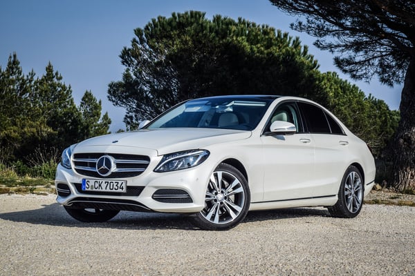 White Mercedes C-Class parked on gravel